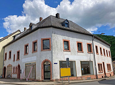 	Wohn- und Geschäftshaus, ehem. Laden mit 2 ½ Wohneinheiten,<br/>Bj. ca. 1945, teilunterkellert, Renovierungsbedürftig<br/>Mauerwerk - Massivbauweise<br/>Satteldach -  mit Naturschiefer eingedeckt, halbe Dachfläche 2020 neu <br/>mit Kunstschiefer eingedeckt <br/>Fenster - Holz und Kunststoff, Isolierverglasung<br/>Haustüre - Holz<br/>Fußböden - Fliesen, PVC, Laminat, Holzdielen,Teppich<br/>Bad - gefliest<br/>Heizung - Ölzentralheizung<br/>Bedarfsausweis mit Endenergie: 228,9 kWh/(m²·a)-Energieeffizienzklasse G,<br/>wesentlicher Energieträger: Öl<br/><br/><br/>Raumaufteilung<br/>Erdgeschoss:<br/>Ladenlokal, Aufenthaltsraum, ehem. Bad, Lager, Flur, WC; Waschküche<br/>Obergeschoss: 	<br/>Whg 1: Wohnzimmer, Küche, Schlafzimmer, Dusche WC<br/>				Whg 2: Wohnzimmer, Küche, 3 Schlafzimmer, Bad WC<br/>				Wohnzimmer, Küche, Schlafzimmer, WC – nicht abgeschlossene Wohnung<br/>Untergeschoss:<br/>	Heiz- und Tankraum<br/><br/>Das Objekt verfügt insgesamt über eine Wohn-/Nutzfläche von ca. 390 m²<br/><br/>Das Grundstück ist ca. 440 m² groß<br/><br/>Unsere Nachweis- oder Vermittlungstätigkeit erfolgt aufgrund der uns vom Auftraggeber, Verkäufer oder anderen Auskunftsbefugten erteilten Auskünfte, so dass für die Vollständigkeit und Richtigkeit dieser Auskünfte sowie aller Informationen keine Gewähr oder Haftung übernommen wird.