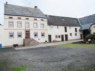 In schön gelegenem Ort, Randlage – ruhige Lage, zentral gelegen – in sich abgeschlossener Innenhof.<br/><br/>Bj. ca. 1807, Massivbauweise, teilunterkellert, Sanierung 1998.<br/>Satteldach mit Naturschiefer eingedeckt<br/>Kunststoffenster-Isolierverglasung, 1979<br/>Fliesen- und Holzdielenböden<br/>Bad deckenhoch hell gefliest<br/>Ölzentralheizung - 1998 (wesentlicher Energieträger), zus. Ofenheizung möglich.<br/>Bedarfsausweis mit Endenergie: 231,1 kWh/(m²·a), Energieeffizienzklasse G.<br/><br/>Raumaufteilung<br/>Erdgeschoss: <br/>Flur, Wohnzimmer, Esszimmer, Wohnküche, Abstellraum, Hauswirtschaftsraum - Gäste WC <br/>Obergeschoss: <br/>Flur, 4 Schlafzimmer, Bad Dusche WC<br/><br/>Das Haus verfügt insgesamt über ca. 175 m² Wohnfläche.<br/><br/>Nebengebäude: <br/>Stallungen, Scheune, Gerätescheune, 2 Garagen; <br/>Massivbauweise, 5 Pferdeboxen<br/>Satteldach mit Naturschiefer und Trapezbleck eingedeckt; <br/>Carport, Schuppen<br/><br/>Sonstiges: <br/>Denkmalschutz<br/><br/>Grundstück: <br/>ca. 6.896 m² - Hofraum und Wiese - Brunnen mit Leitungen zur Wiese (Tränke).