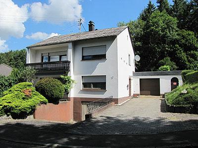 Einfamilienhaus in ruhiger Randlage<br/><br/>Bj.1981, das Objekt befindet sich bis auf ein paar<br/> Instandhaltungsarbeiten in gutem Zustand.<br/> <br/><br/>Massivbauweise - Yton Isolierstein, voll  unterkellert<br/>Satteldach mit Betonpfannen eingedeckt<br/>Holzfenster-Isolierverglasung mit Rölläden<br/>Fliesen- und Teppichböden<br/>Geflieste Bäder<br/>Elektronachtspeicherheizung (wesentlicher Energieträger), <br/>				zzgl. offener Kamin<br/><br/><br/>Raumaufteilung<br/><br/>Erdgeschoss:<br/>Diele, großes Wohn-/ Esszimmer mit offenem Kamin und Terrasse, <br/>Wohnküche mit Abstellraum, Schlafzimmer, Dusche WC, Gäste WC;<br/>Garage<br/><br/>Dachgeschoss:<br/>Diele, 4 Schlafzimmer, Bad Dusche WC<br/>- 1 Zimmer mit Küchenanschlüssen, als separate Wohnung nutzbar.<br/><br/>Untergeschoss<br/>3 Kellerräume<br/><br/>Grundstück:<br/>Größe 1.081 m², Hofraum und Wiese - Gartenanlage