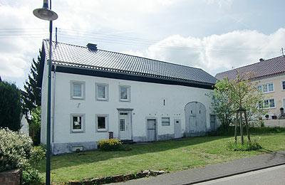 Rustikales Bauernhaus Nähe Daun - in Waldreicher Umgebung<br/><br/>Bj. ca. 1900, im laufe der Jahre wurden immer wieder Renovierungs- und Instandhaltungsmaßnahmen durchgeführt - weitere sind  im Wohnbereich erforderlich.<br/><br/>Massive Bauweise <br/>Satteldach mit Tonpfannen (Edelengoben) eingedeckt - Eindeckung mit Aufdachdämmung (PUR Dämmplatten beidseitig alukaschiert) 2008 über das gesamte Gebäude erneuert<br/>Kunststoffenster, Isolierverglasung - 1988 erneuert<br/>Haustüre - Kunststoff, 2012 erneuert<br/>Fliesen-, Teppich- und Holzdielenböden<br/>Bad deckenhoch gefliest <br/>Elektronachspeicherheizung - 2010 erneuert, wesentlicher Energieträger, - zus. Kaminofen<br/>Stromanschluss, moderner Zählerkasten und E-Heizkörper 2010 erneuert.<br/><br/><br/>Raumaufteilung:<br/><br/>Erdgeschoss:<br/>Flur, Wohnzimmer, Küche, Esszimmer<br/><br/>Obergeschoss:<br/>Flur, 3 Schlafzimmer, Bad Dusche WC<br/><br/>Nebengebäude - Ausbaureserve<br/>Stallungen, Scheune<br/>- massivbauweise<br/>- Satteldach mit Tonpfannen (Edelengoben) eingedeckt - Eindeckung mit Aufdachdämmung (PUR Dämmplatten beidseitig alukaschiert) 2008 erneuert<br/><br/>Grundstück:<br/>720 m², Hofraum und Wiese mit Baumbestand